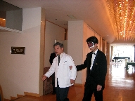 写真：視覚障害者ガイドで広い廊下を通るところ