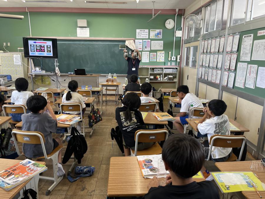 活性汚泥が入ったボトルを見る4年生