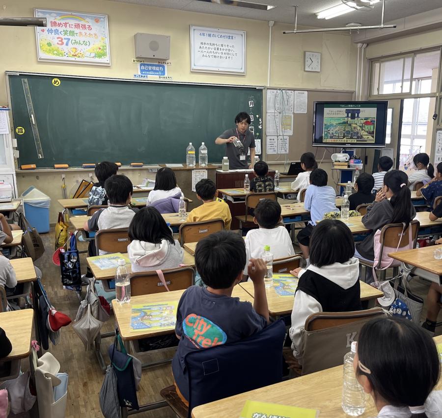 活性汚泥が入ったボトルを見る4年生