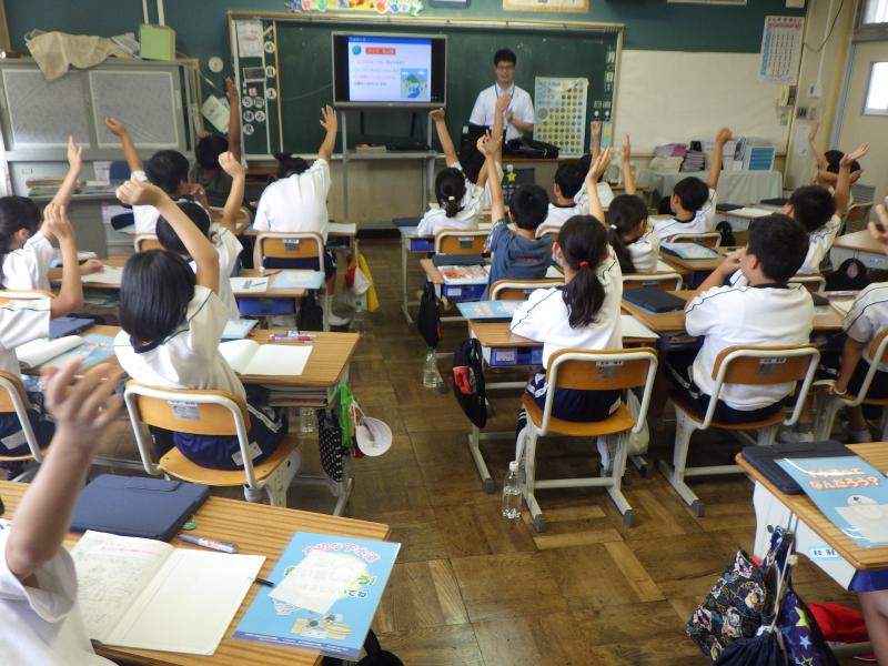 手を挙げる児童の様子、写真