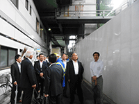神田駅付近の工事現場でプロジェクトや工事の概要について説明を受ける様子