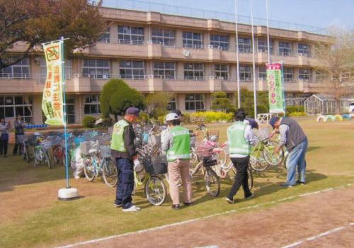 写真。小学校で自転車を1台ずつ確認する皆様