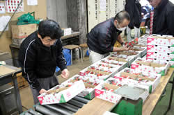 写真：出荷されたイチゴの検査をする検査員とＪＡ職員